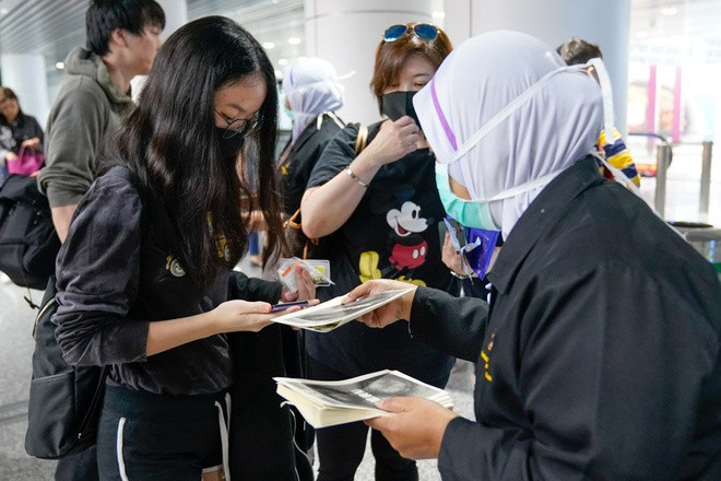 Được biết, cảnh sát Malaysia đã bắt giữ 6 người vì phát tán thông tin sai lệch về virus corona, theo thông báo của Cơ quan Truyền thông và Đa phương tiện Malaysia. Ảnh: Các nhân viên y tế đang phát tờ rơi cho du khách tại sân bay quốc tế Kuala Lumpur, Malaysia. Ảnh: AP.