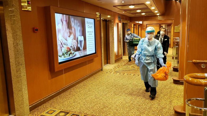 Người đàn ông mặc đồ bảo hộ trong khoang thứ 6 trên du thuyền Diamond Princess ở Yokohama ngày 4/2/2020. Hành khách trên tàu được yêu cầu ở trong phòng và đồ ăn sẽ được đưa đến tận nơi cho họ.