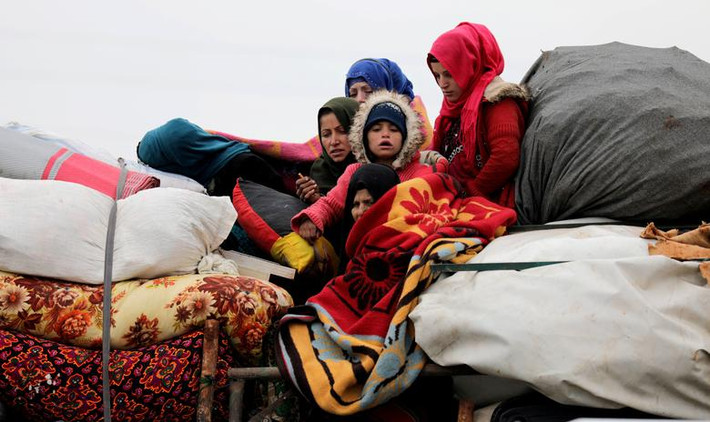 Những người dân sơ tán từ vùng nông thôn phía tây Aleppo ngồi trên một chiếc xe cùng đồ đạc ở Hazano, gần Idlib, ngày 11/2.
