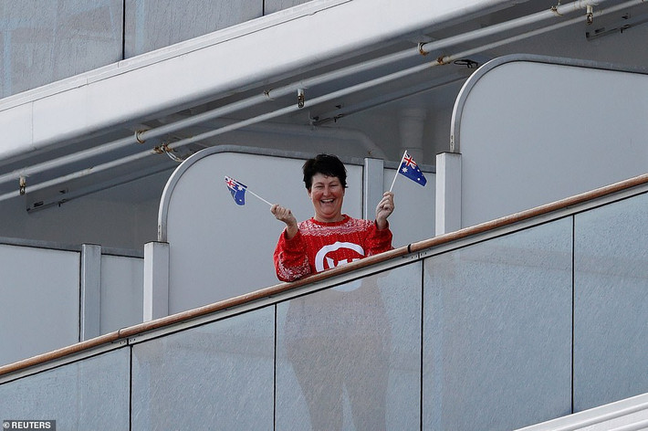 Nữ hành khách vẫy cờ Australia khi đứng ở ban công trên du thuyền Diamond Princess.