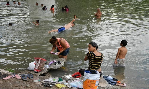 Sông Rio Grande gần khu trại tị nạn tạm bợ ở Matamoros trở thành nơi tắm rửa của hàng trăm người nhập cư tìm cách vào Mỹ.