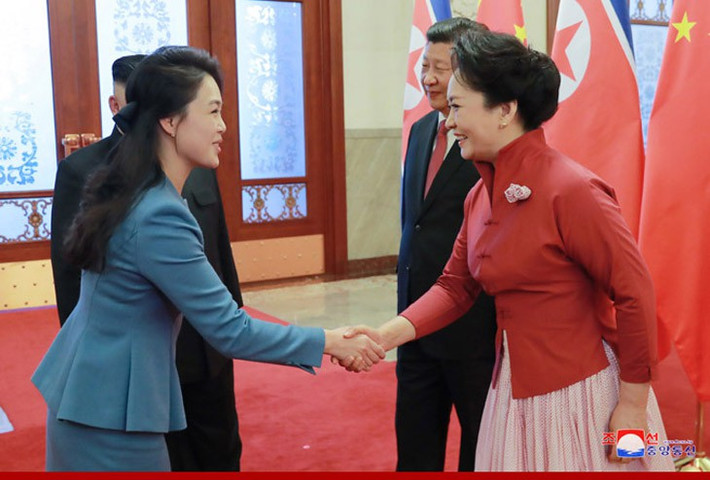 Bà Ri Sol-ju (trái) bắt tay bà Bành Lệ Viện trong cuộc gặp hồi đầu năm. Ảnh: KCNA.