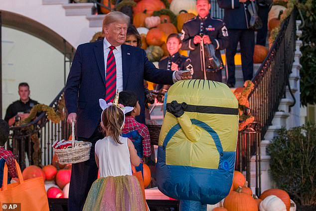Tổng thống Mỹ Donald Trump đặt kẹo lên đầu một chú "minion".