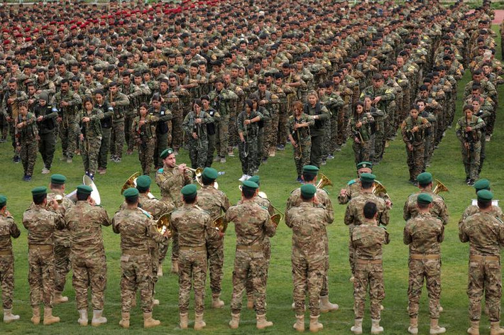 Được biết, đây là cuộc tấn công vào Syria lần thứ ba của Thổ Nhĩ Kỳ, kể từ năm 2016. Thổ Nhĩ Kỳ có hai mục tiêu chính ở Đông Bắc Syria: Đánh đuổi lực lượng dân quân người Kurd YPG mà họ coi là mối đe dọa an ninh biên giới và tạo ra vùng an toàn, tạo điều kiện cho 2 triệu người tị nạn Syria trở về nhà. Ảnh: Các chiến binh người Kurd thuộc Đơn vị Bảo vệ Nhân dân (YPG) diễu hành quân sự tại Qamishli ngày 28/3/2019.
