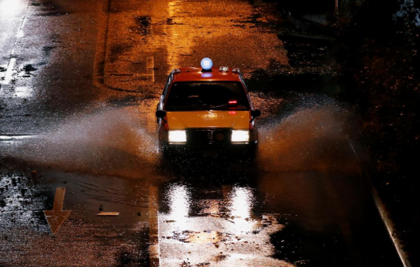 Chiếc xe taxi đi qua con đường ngập nước ở Yokohama.