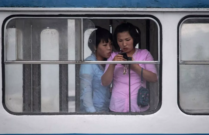 Hai người phụ nữ xem điện thoại khi ở trên xe.