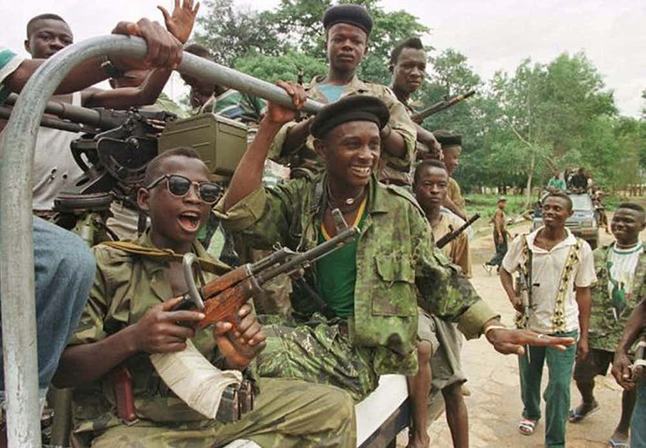 Vào những năm 1990, Sierra Leone trải qua cuộc nội chiến tàn bạo dưới thời Tổng thống khi đó là Charles Taylor. Sau này, Taylor đã bị kết án 11 tội ác chiến tranh, trong đó có tội sử dụng chiến binh “nhí” trong cuộc nội chiến. Trong ảnh: Một nhóm binh sĩ ở vùng ngoại ô Freetown ở Sierra Leone năm 1997.