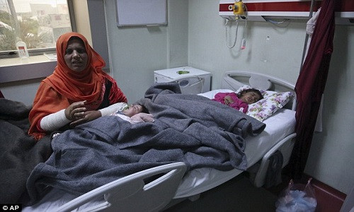Cô Ekhlas Meshal, 30 tuổi, bế con gái Ranmea mới được 2 tháng tuổi. Cô con gái Dima của Ekhlas cũng đang phải điều trị trong bệnh viện.