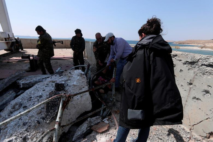 Lực lượng SDF và người dân kiểm tra hư hại ở phần phía bắc con đập lớn nhất Syria.