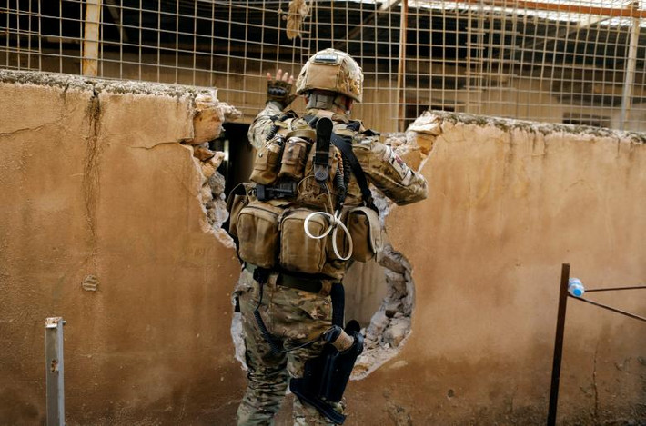 Một thành viên của lực lượng phản ứng nhanh Iraq đang di chuyển từ ngôi nhà này sang ngôi nhà khác để tránh bị các tay súng bắn tỉa IS tấn công ở khu vực Tây Mosul.
