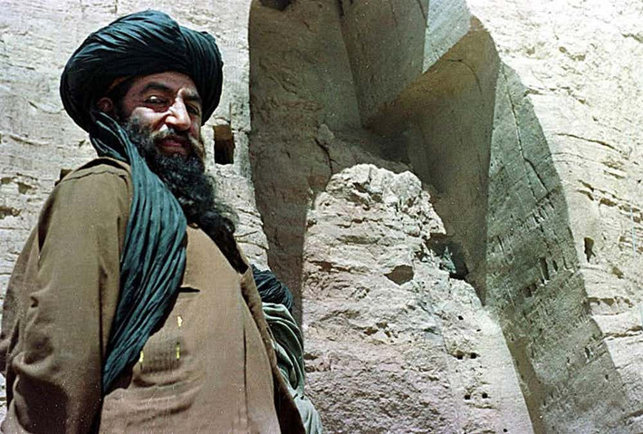 Một chiến binh Taliban đứng trước bức tượng Phật cổ khổng lồ đã bị nhóm khủng bố này phá hủy trong chiến tranh.