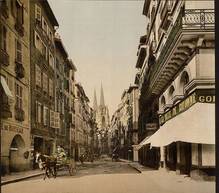 Chiếc xe ngựa đi qua dãy nhà cao tầng ở Bayonne.