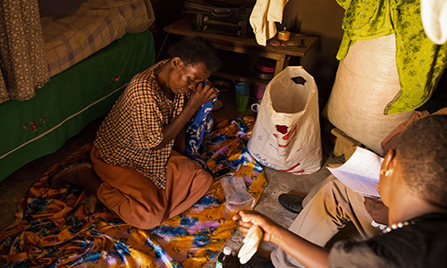 Monica Nakayima ngồi khóc trong nhà của cô ở Jinja, Uganda. Được biết, Monica có triệu chứng bị ung thư buồng trứng.