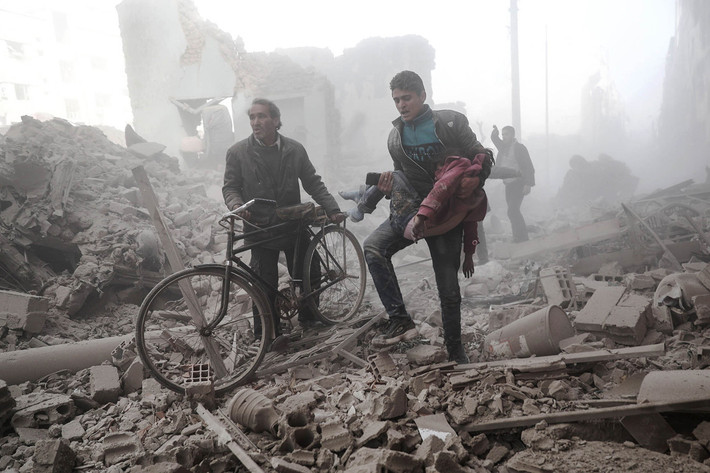 Người đàn ông Syria bế một em nhỏ bị thương sau vụ không kích ở thị trấn Douma, vùng ngoại ô phía đông thủ đô Damascus, ngày 25/2/2017.
