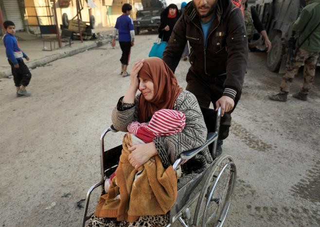 Người phụ nữ Iraq khóc khi ngồi trên xe lăn sơ tán khỏi thành phố Mosul.