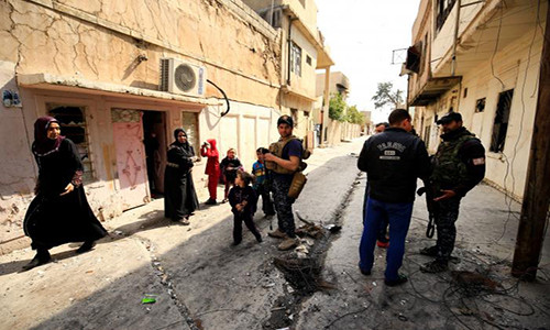Cảnh sát Iraq hỏi han dân thường ở khu Dawasa, Mosul, trong ngày Quốc tế Phụ nữ 8/3.