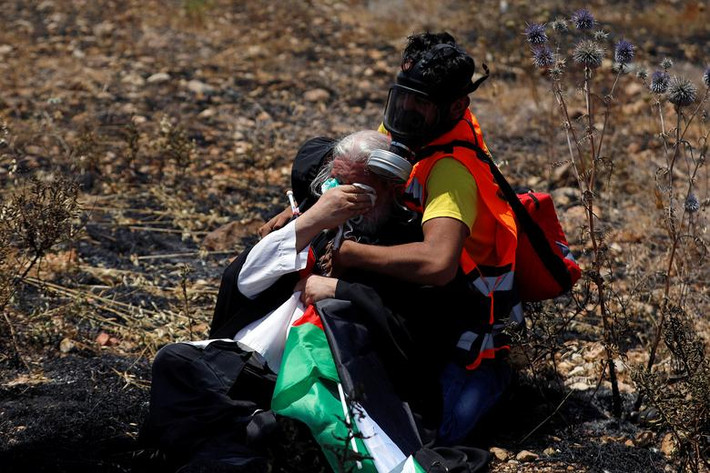 Người biểu tình Palestine trúng hơi cay của lực lượng an ninh Israel hôm 25/6. Ảnh: Reuters.