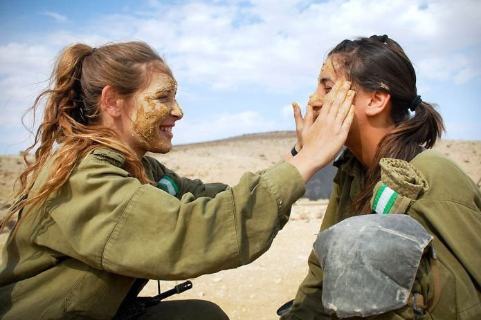 Đắp ngụy trang cho nhau trên thao trường. Nữ quân nhân Israel sở hữu vóc dáng khỏe khoắn và gợi cảm.