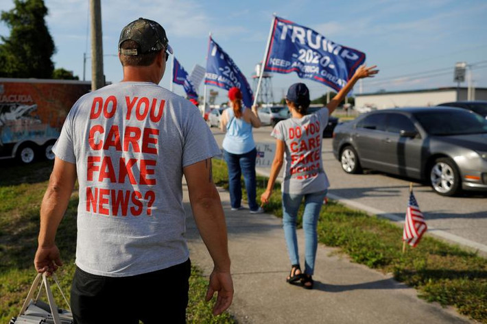Một số người ủng hộ ông Trump mặc áo in dòng chữ có nội dung "Bạn có quan tâm đến những tin tức giả mạo" ngày 15/5.
