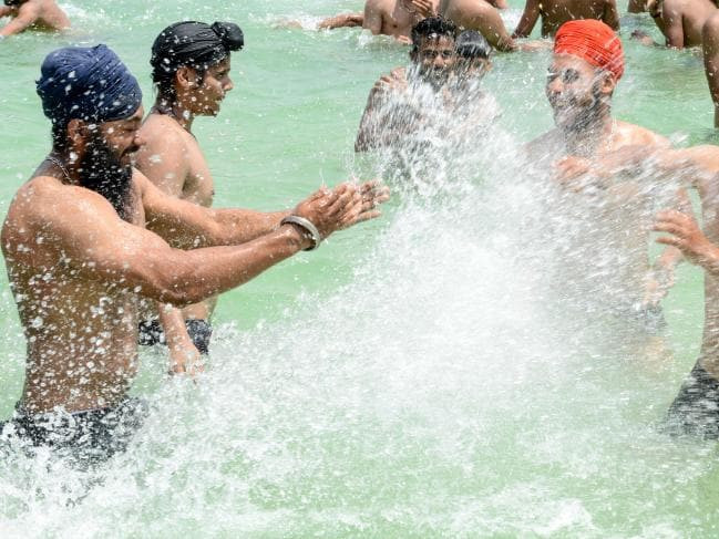 Các thanh niên Ấn Độ đi bơi trong một ngày nắng nóng ở Amritsar hôm 2/6. Ảnh: News.com.