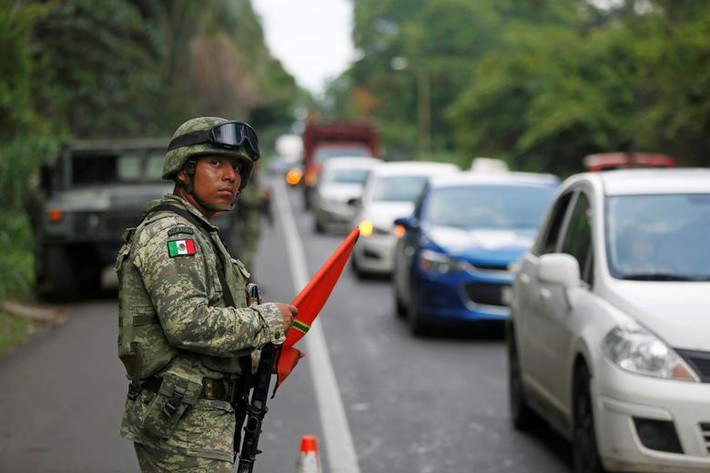 Cảnh sát Mexico đứng quan sát trên một con đường ở Tapachula, Mexico, ngày 14/6.