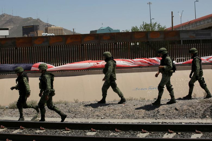Các binh sĩ Mexico tuần tra cạnh hàng rào biên giới ở Ciudad Juarez.