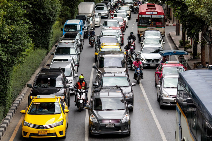Một tài xế xe ôm và hành khách đi trên đường phố Bangkok. Sự cạnh tranh và bạo lực giữa các tài xế môtô taxi tăng lên kể từ tháng 10/2017, khi các ứng dụng gọi xe tương tự Uber ra mắt tại Thái Lan. Mức giá của Grab vượt qua các tài xế địa phương với những chuyến đi ngắn có giá chỉ 40 baht (1,3 USD), đôi khi chỉ bằng một nửa so với xe ôm đường phố.