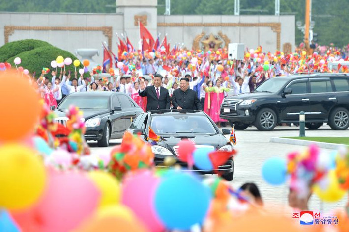 Đông đảo người dân Triều Tiên vẫy cờ hoa chào đón hai bên đường từ sân bay Bình Nhưỡng về Cung điện mặt trời Kumsusan, lăng mộ của nhà sáng lập Triều Tiên Kim Nhật Thành.