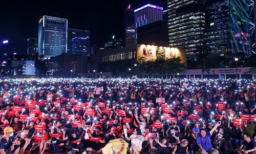 Đám đông người biểu tình mang theo những tấm biển có nội dung như "Hãy giúp Hong Kong" tuần hành tới các tòa lãnh sự quán các nước đặt tại thành phố này.