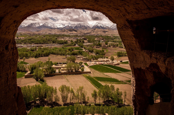 Khung cảnh của thung lũng Bamiyan, với những dãy núi phủ tuyết trắng ở phía xa và những cánh đồng màu xanh, khi nhìn ra từ vị trí đặt bức tượng trước đây. Ảnh: New York Times. *) Title do Kiến Thức biên tập lại