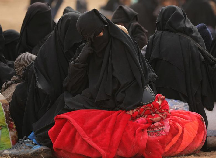 Những người phụ nữ mang theo đồ đạc trên đường đi sơ tán khỏi Baghouz.