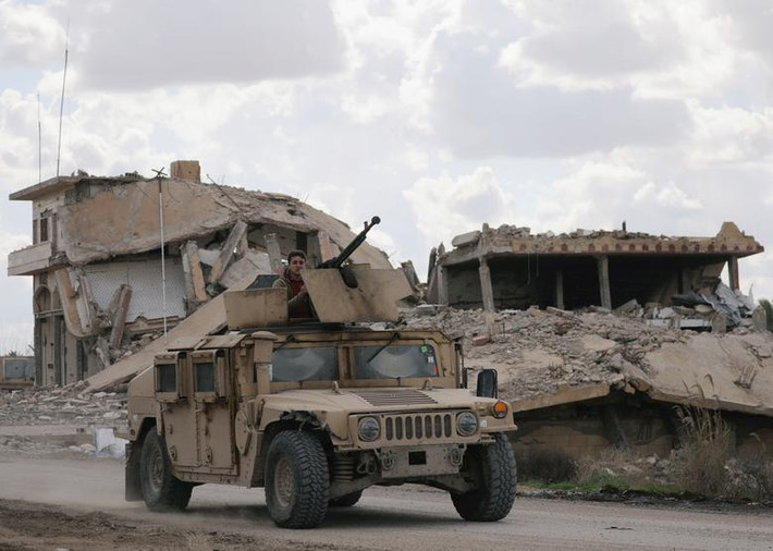 Một chiến binh SDF trên xe quân sự di chuyển trong ngôi làng Baghouz hôm 18/2.