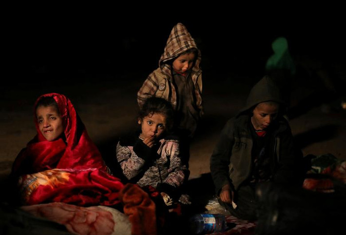 Các em nhỏ ngồi nghỉ khi trời tối gần ngôi làng Baghouz ngày 25/2.