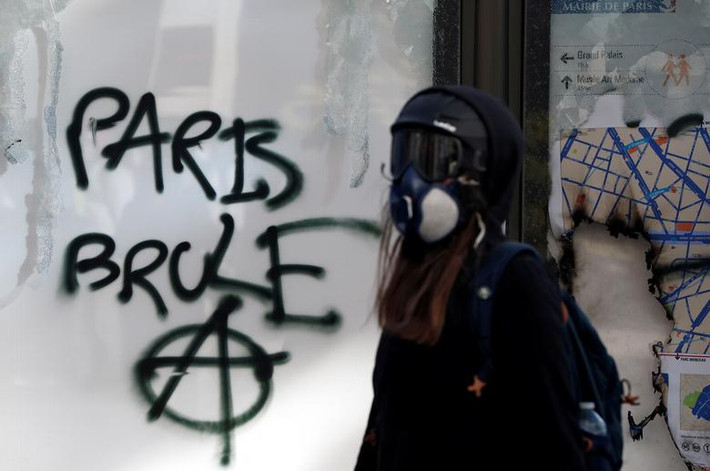Một người biểu tình đeo mặt nạ ở thủ đô Paris ngày 16/3.