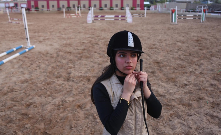 Fatma Youssef, 17 tuổi, một học sinh trung học Palestine chuẩn bị cưỡi ngựa tại một câu lạc bộ. "Cháu cảm thấy lo lắng vì đây là năm học cuối. Nhưng mọi lo âu đều biến mất khi cưỡi ngựa", Fatma chia sẻ.