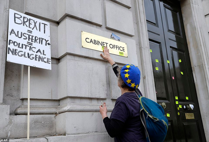Một người biểu tình dán sticker phản đối Brexit trước lối vào Văn phòng Nội các Anh ngày 23/3.