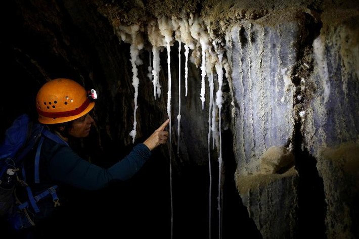 Một phụ nữ nhìn ngắm thạch nhũ trắng trong hang Malham ngày 27/3. Ảnh: Reuters. \