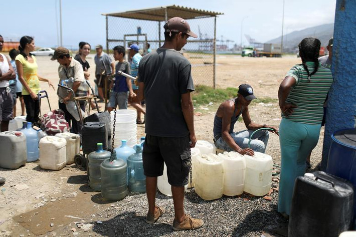 Người dân Venezuela đổ đầy các bình nước để tích trữ ở La Guaira ngày 13/3.