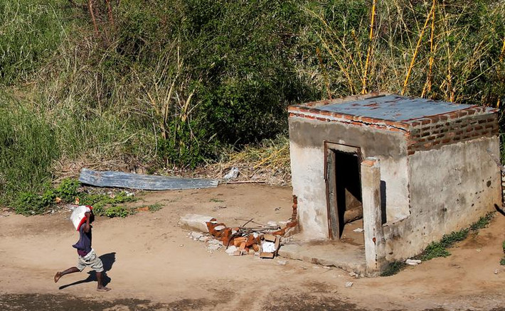 Người đàn ông mang đồ cứu trợ về nhà ở làng Nhamatanda, Mozambique, hôm 26/3.