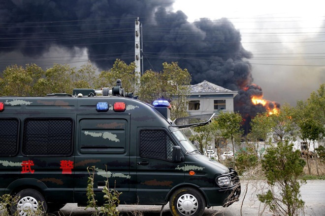 Xe của lực lượng an ninh Trung Quốc đỗ gần hiện trường vụ nổ. Ảnh: Reuters.