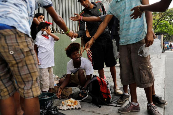 Theo hãng thông tấn Reuters, nhiều người dân nghèo ở thủ đô Caracas, Venezuela, đã phải tìm đồ ăn trong bãi rác do giá cả thực phẩm đắt đỏ trong khi nước này vẫn chìm trong khủng hoảng. Ảnh: Một số thiếu niên ăn chiếc bánh mà họ tìm thấy trong một túi rác ở thủ đô Caracas ngày 27/2. (Nguồn ảnh: Reuters)