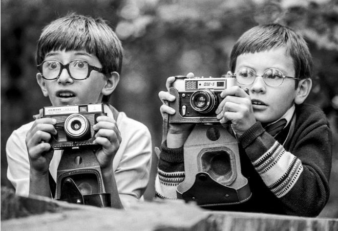 Hai em nhỏ cầm máy ảnh hồi thập niên 1980.