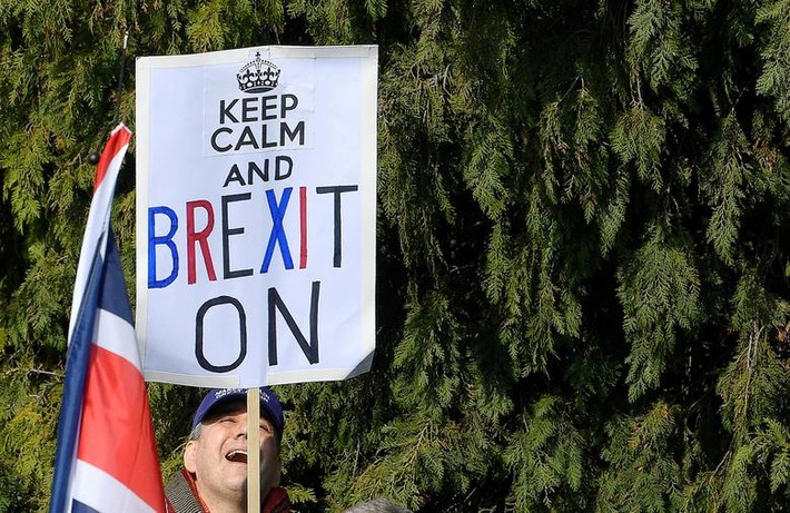 Một người ủng hộ Brexit mang theo tấm biển có dòng chữ với nội dung kêu gọi mọi người bình tĩnh và tiếp tục tiến trình Brexit.