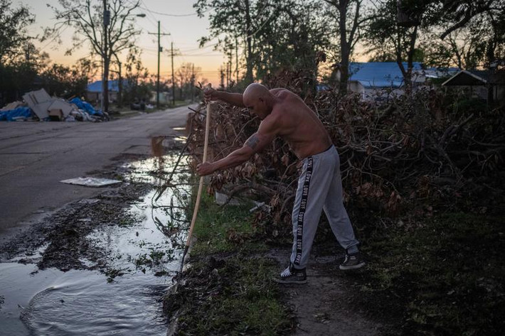Jose Rodriguez dọn dẹp trước nhà ở Lake Charles, bang Louisiana, hôm 10/10 sau khi bão Delta đi qua.