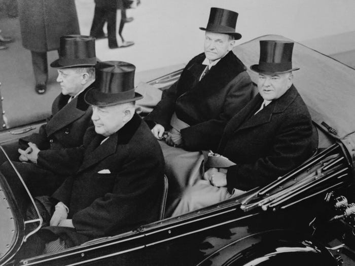 Tổng thống Mỹ thứ 30 Calvin Coolidge (trái) ngồi cạnh Tổng thống thứ 31 của nước Mỹ Herbert Hoover trên xe (ở ghế sau) khi tới lễ nhậm chức của ông Hoover năm 1929.