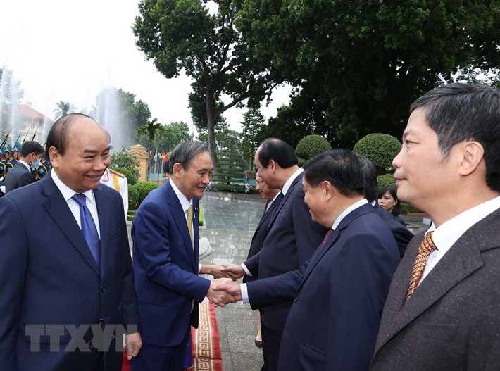 Thủ tướng Nhật Bản Suga Yoshihide với các thành viên chính thức Đoàn đại biểu Việt Nam tại Lễ đón. (Ảnh: Thống Nhất/TTXVN)