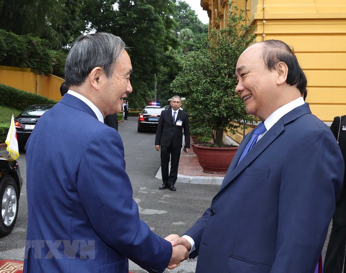 Thủ tướng Nguyễn Xuân Phúc đón Thủ tướng Nhật Bản Suga Yoshihide. (Ảnh: Thống Nhất/TTXVN)