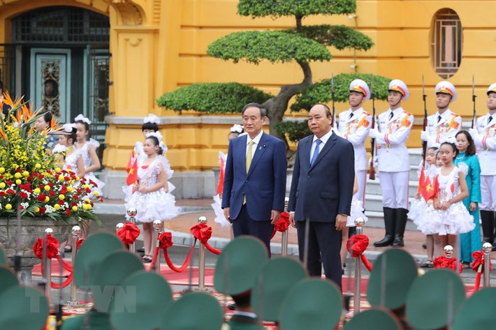 Thủ tướng Nguyễn Xuân Phúc và Thủ tướng Nhật Bản Suga Yoshihide trên bục danh dự, nghe quân nhạc cử Quốc thiều hai nước. (Ảnh: Lâm Khánh/TTXVN)