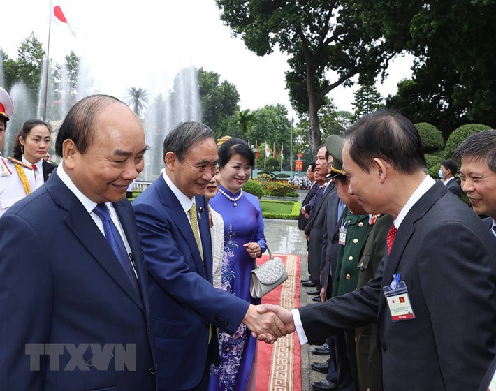 Thủ tướng Nhật Bản Suga Yoshihide với các thành viên chính thức Đoàn đại biểu Việt Nam tại Lễ đón. (Ảnh: Thống Nhất/TTXVN)