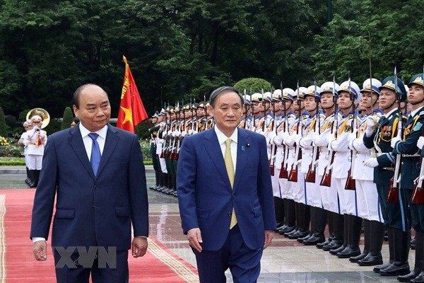 Thủ tướng Nguyễn Xuân Phúc và Thủ tướng Nhật Bản Suga Yoshihide duyệt đội danh dự QĐND Việt Nam. (Ảnh: Thống Nhất/TTXVN)
